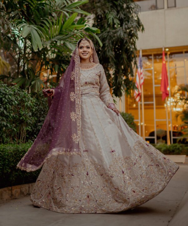 Rose gold and magenta toned lehenga with heavy handwork embellishment on the blouse and borders of lehenga